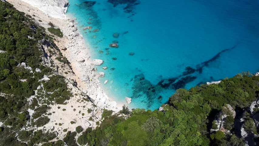 a large body of water next to a sandy beach, by Julian Allen, pexels contest winner, capri coast, looking down on the camera, alexandros pyromallis, tiffany dover