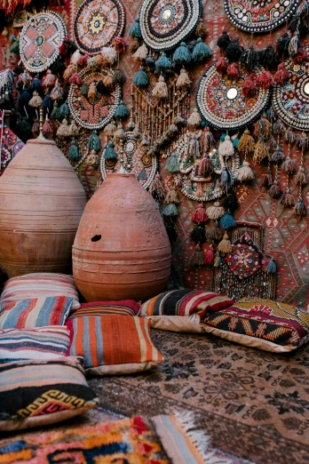 a room filled with lots of different types of rugs, inspired by Riad Beyrouti, trending on unsplash, vases and bottles, interior of a tent, oman, panoramic shot