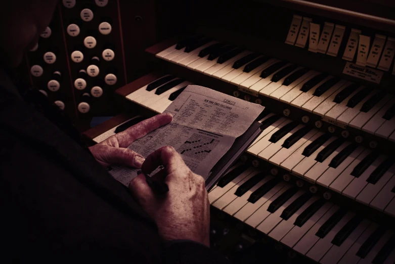 a close up of a person playing an organ, an album cover, unsplash, paul barson, analog horror, priest, handwritten