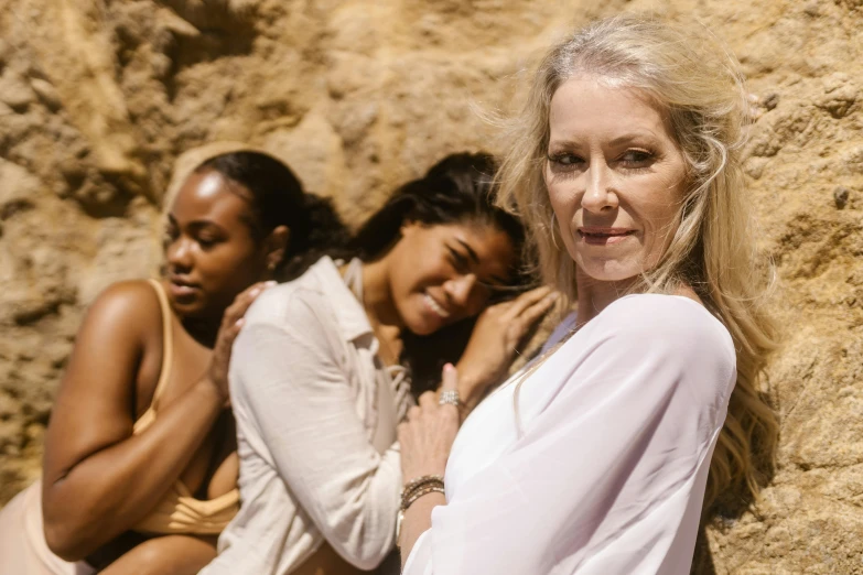 a group of women sitting next to each other, by Lee Loughridge, unsplash, renaissance, songlines, close up of a blonde woman, scene from the film, her skin is light brown