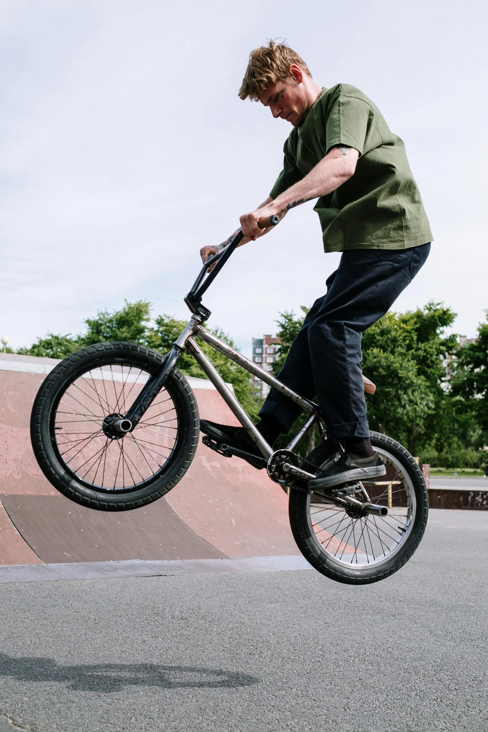 a man flying through the air while riding a bike, inspired by Seb McKinnon, unsplash, realism, stainless steal, brown, teenage boy, gnarly