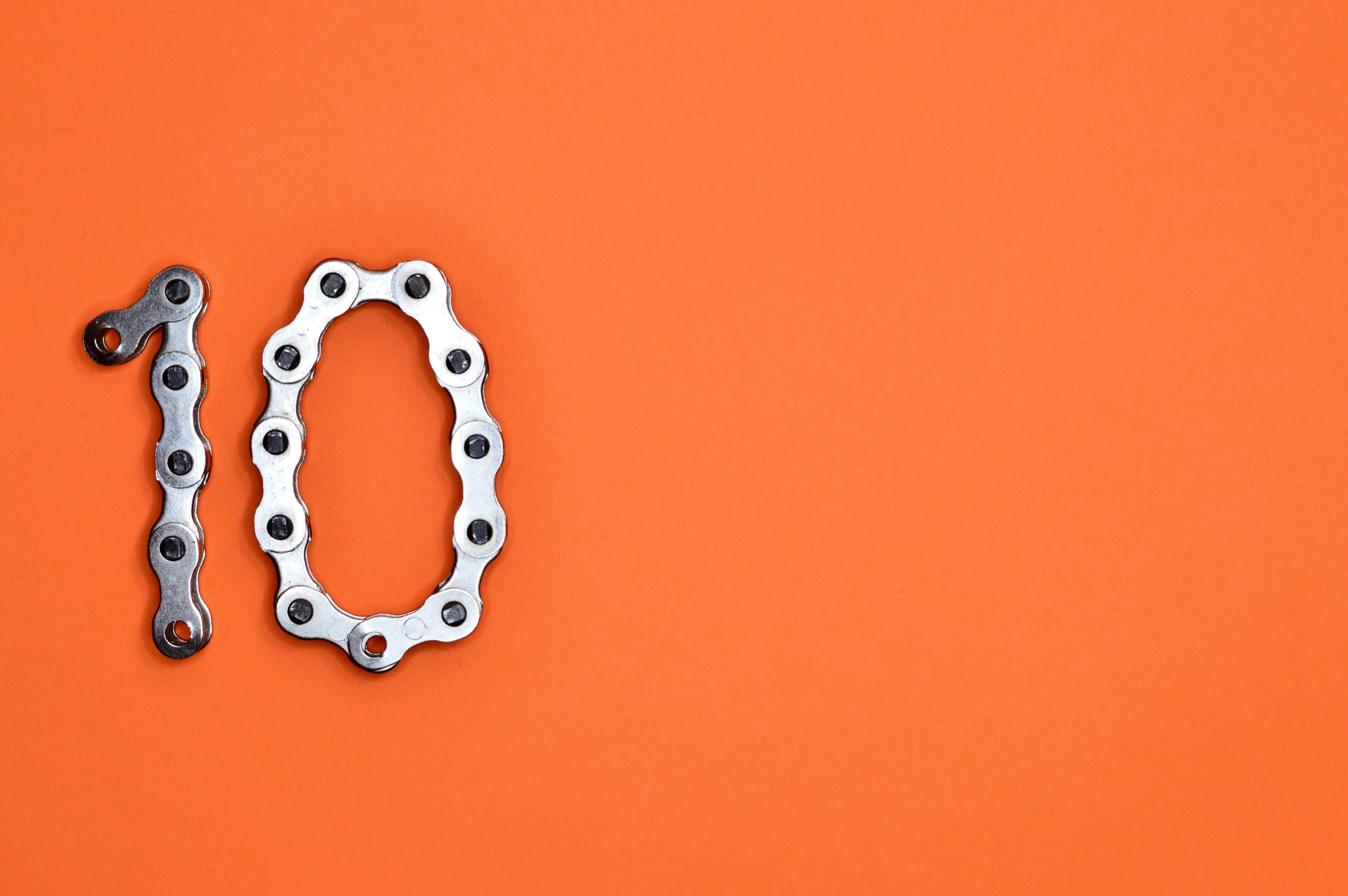 a bicycle chain on an orange background, inspired by Lubin Baugin, trending on pexels, metal teeth, maths, hook as ring, negative space