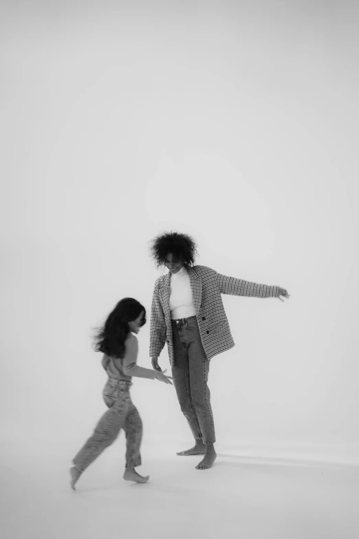 a woman standing next to a man on top of a snow covered ground, a black and white photo, by Clifford Ross, pexels contest winner, conceptual art, dancing with each other, in a white room, with afro, boy and girl