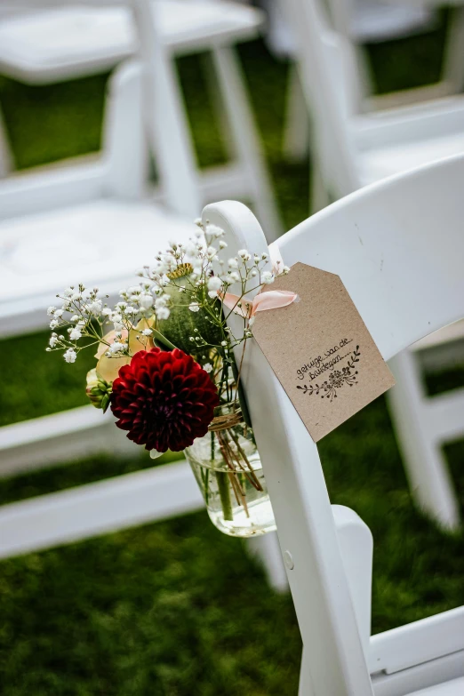 a vase filled with flowers sitting on top of a white chair, label, ceremony, moderately detailed, event