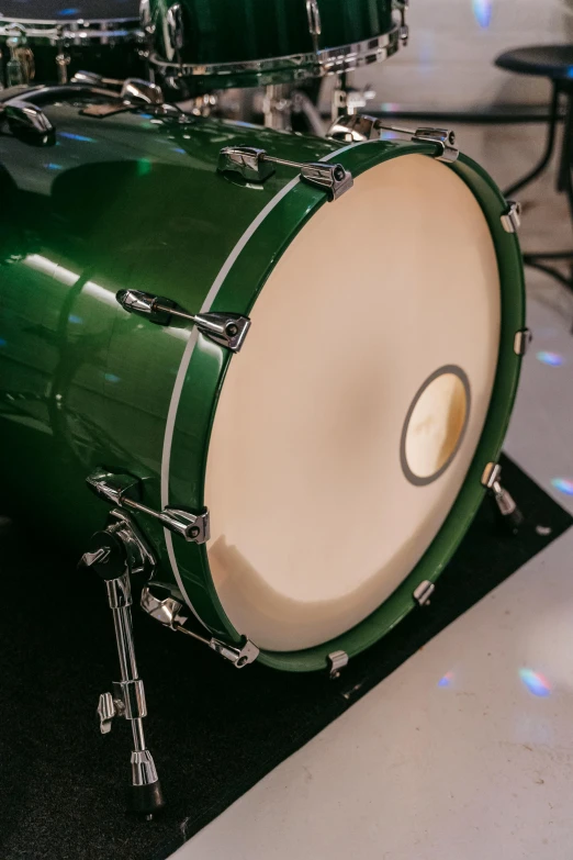 a green drum sitting on top of a black mat, octane fender, pearlized, detailed shot legs-up, taken in the early 2020s