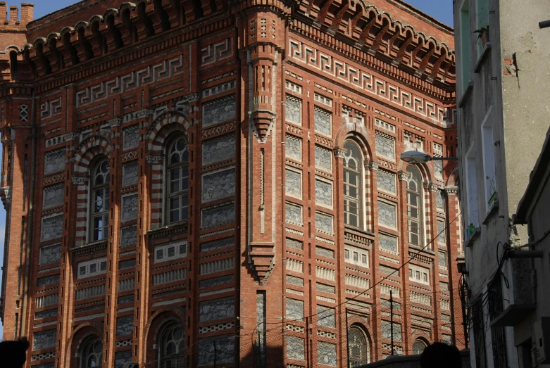 a tall building with a clock on top of it, by Serhii Vasylkivsky, pexels contest winner, art nouveau, red bricks, side view intricate details, concert, hexagonal shaped