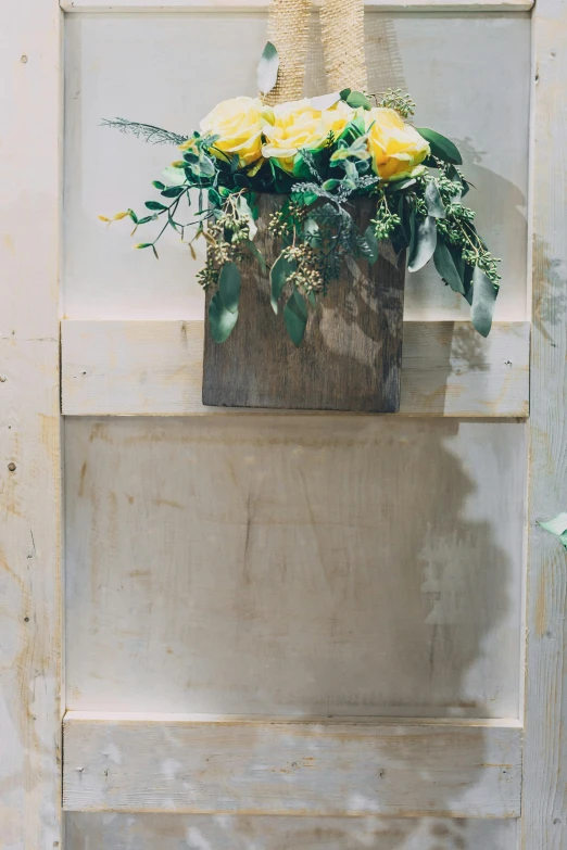 a vase filled with yellow flowers on top of a wooden ladder, by Kristin Nelson, romanticism, wood door, full screen, rectangle, dressed in a worn