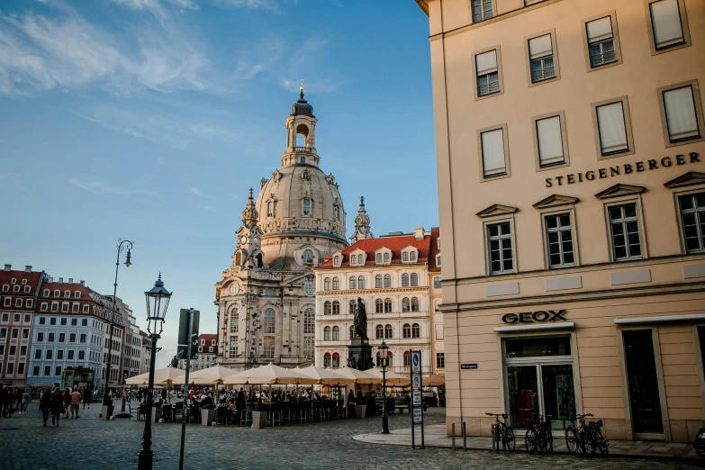 a clock tower sitting on the side of a building, by Matthias Stom, pexels contest winner, baroque, city streetscape, with great domes and arches, soft glow, square