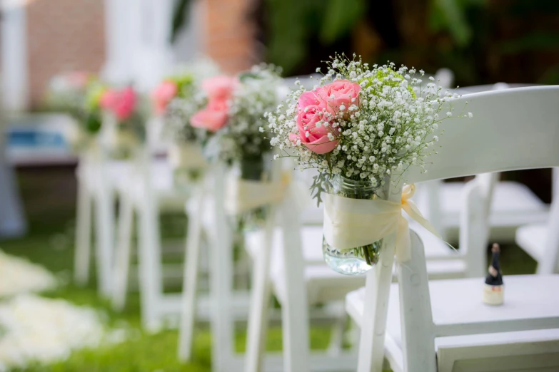 a row of white chairs sitting on top of a lush green field, a picture, pexels, happening, bouquets, white and pink, bokeh intricate details, ceremonial