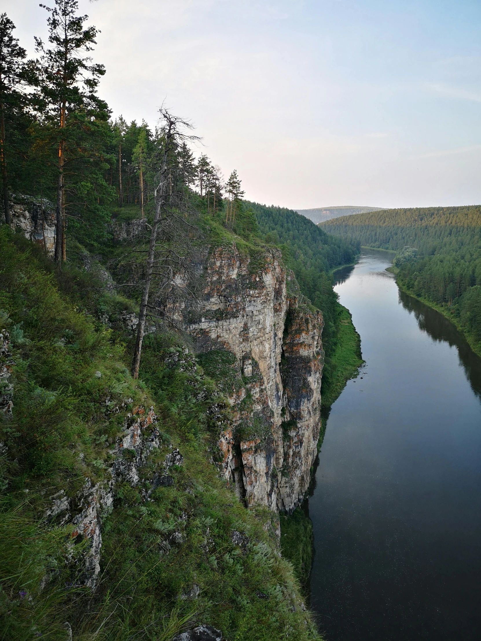 a river running through a lush green forest, an album cover, by Pavel Fedotov, pexels contest winner, hurufiyya, cliff side at dusk, panoramic view, white, cheeks