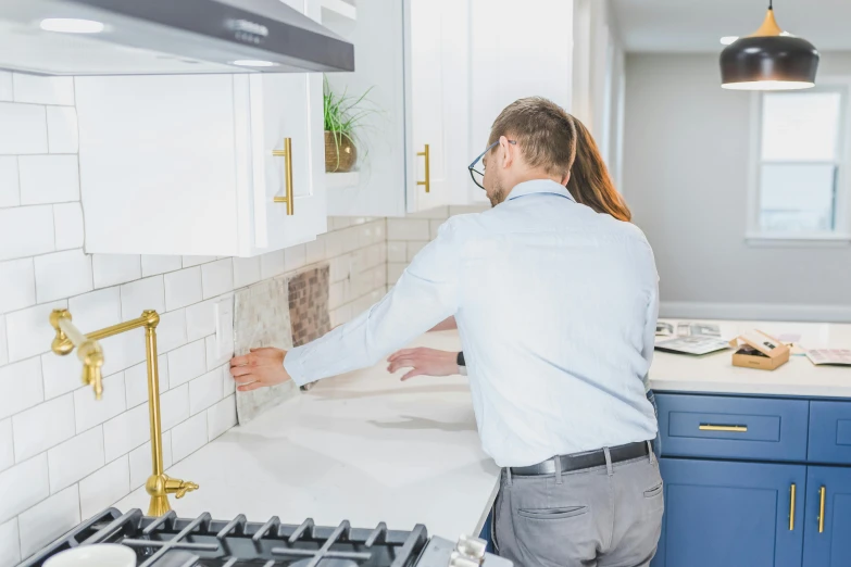 a man fixing a sink in a kitchen, a mosaic, unsplash, background image, joanna gaines, customers, inspect in inventory image