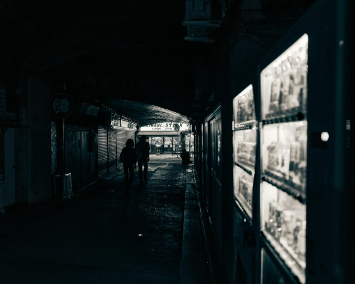 a black and white photo of a subway station, inspired by Elsa Bleda, pexels contest winner, serial art, in an alley at night back lit, people walking down a street, vhs footage of a movie set, gallery display photograph