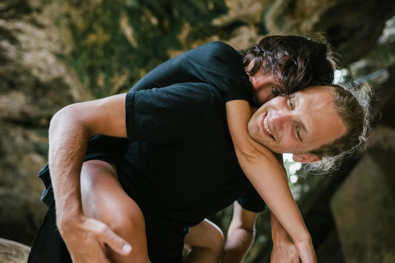 a man carrying a woman on his back, by Lee Loughridge, pexels contest winner, natural cave wall, playful smirk, sweating, lachlan bailey