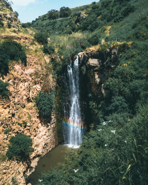 a waterfall with a rainbow in the middle of it, les nabis, ariel view, high quality product image”