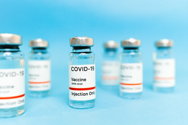 a row of vials filled with vaccines on a blue background, a picture, shutterstock, visual art, instagram post, covid, grey, ƒ/5.6