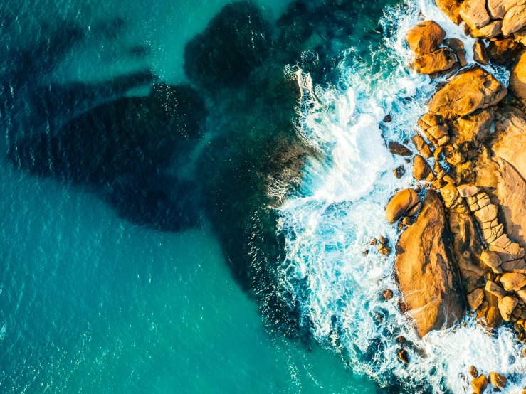 a large body of water surrounded by rocks, pexels contest winner, gold coast australia, aerial iridecent veins, ocean spray, thumbnail