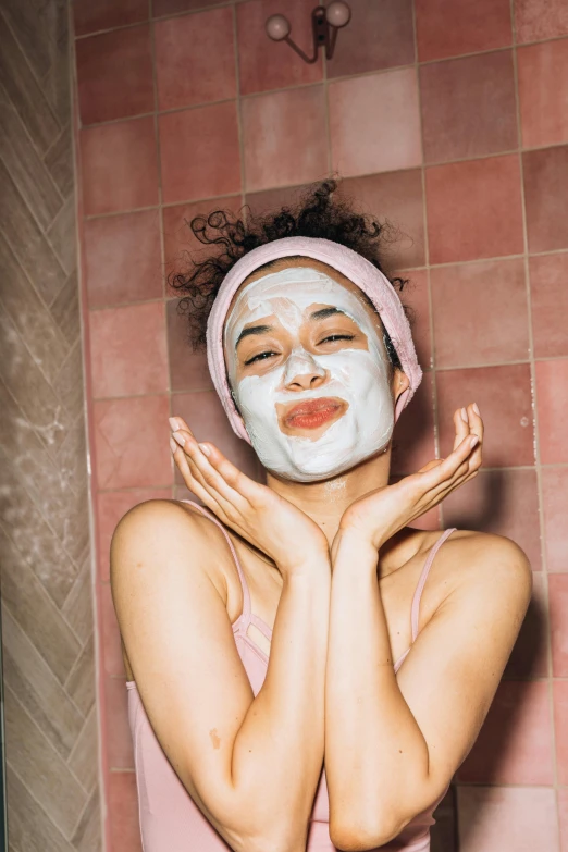 a woman wearing a face mask in a bathroom, by Julia Pishtar, trending on pexels, renaissance, happy facial expression, asian face, pink face, square facial structure