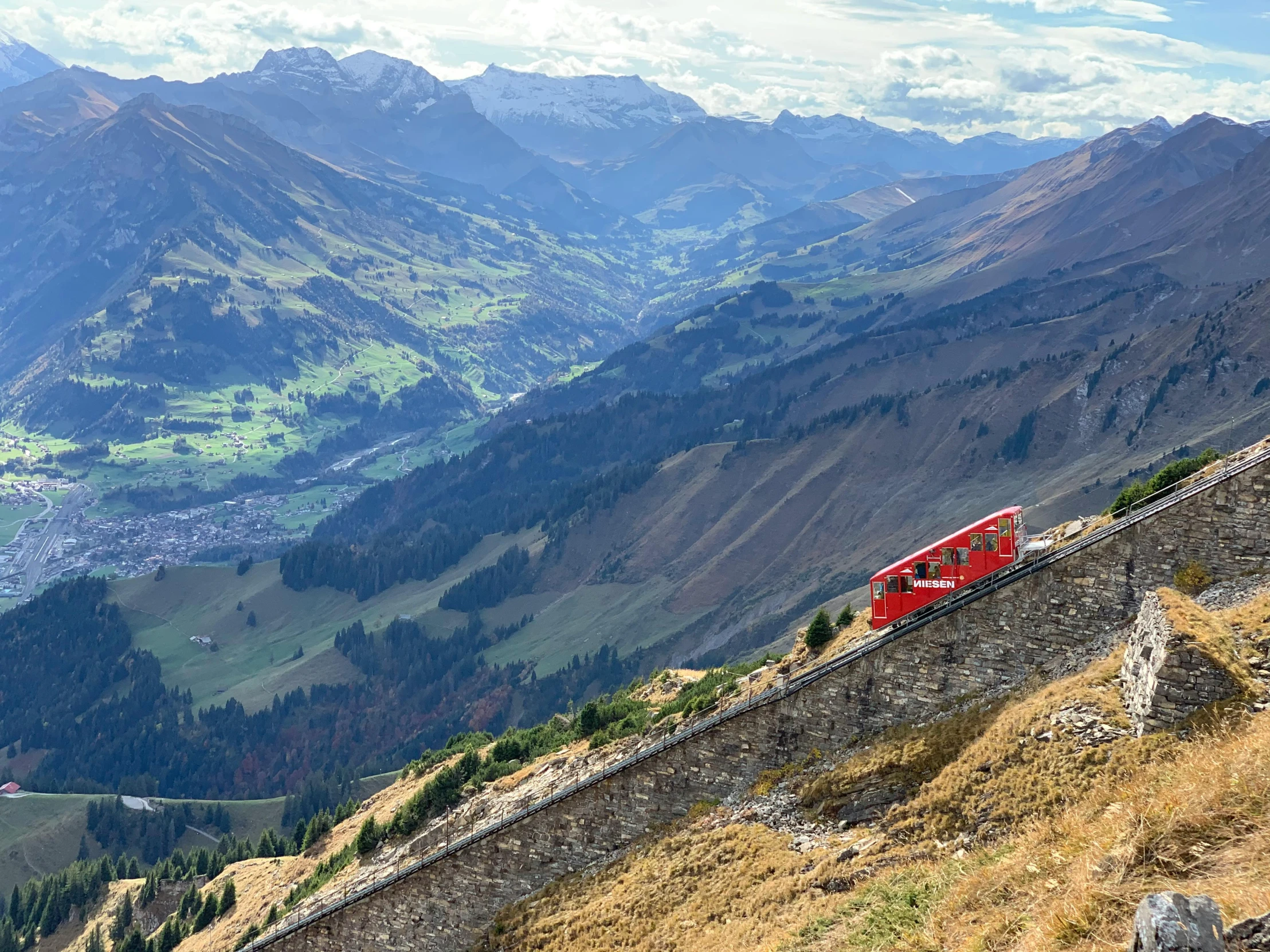 a red train traveling down the side of a mountain, by Werner Andermatt, pexels contest winner, panorama view, 🦩🪐🐞👩🏻🦳, geiger, epicurious