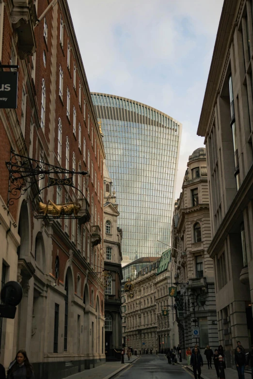 a group of people walking down a street next to tall buildings, inspired by Richard Wilson, art nouveau, huge glass structure, central hub, looking downwards, curvy build