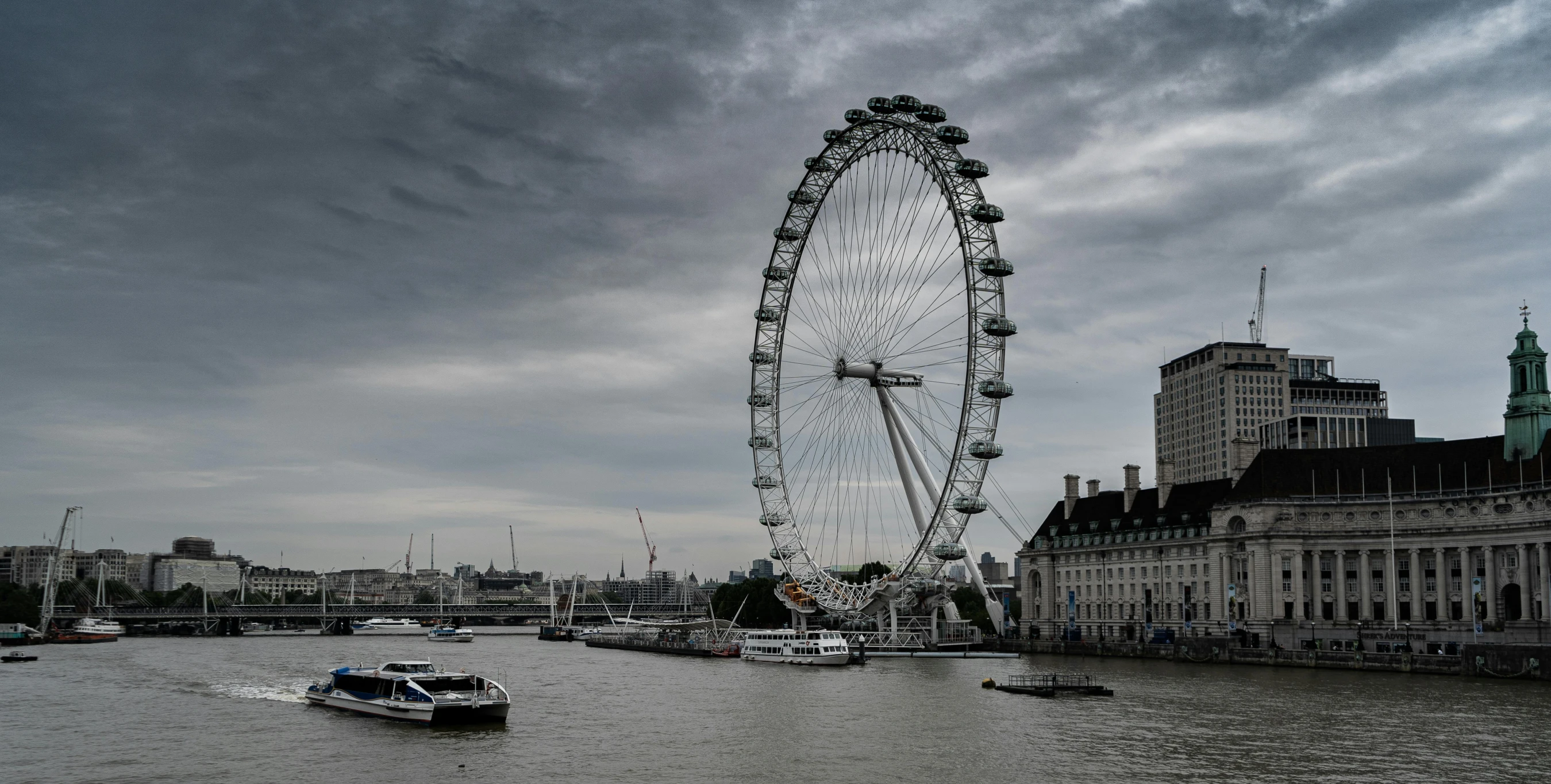 a large ferris wheel sitting in the middle of a river, by Joseph Severn, pexels contest winner, hurufiyya, london architecture, gray clouds, 2040, royal photo