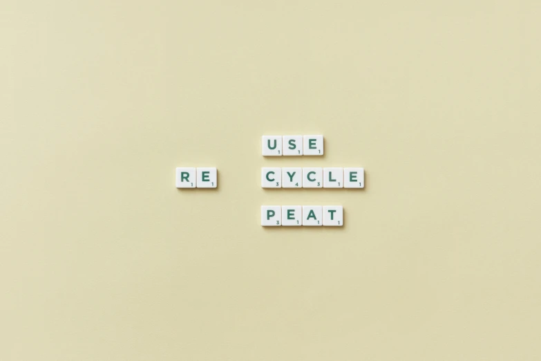a couple of scrabbles sitting on top of a table, by Romain brook, unsplash, visual art, plastic waste, cycles, terminal text, on a pale background