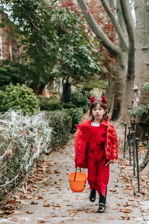 a little girl in a red costume walking down a sidewalk, bats, sydney sweeney, washington dc, in a graveyard