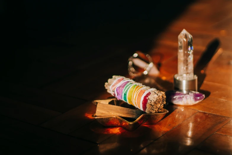 a pair of scissors sitting on top of a wooden table, organic crystals, an altar of a temple, muted rainbow tubing, image