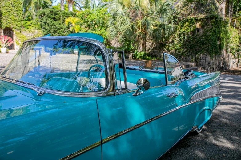 a blue car parked on the side of the road, by Gavin Nolan, pexels contest winner, palm springs, 1957 chevrolet bel air, tropical style, soft top roof raised