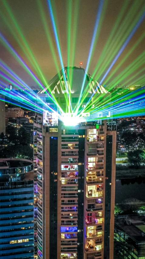 a very tall building with a lot of lights on top of it, a hologram, pexels contest winner, holography, laser beam ; outdoor, laser guns, birdseye view, multi colour