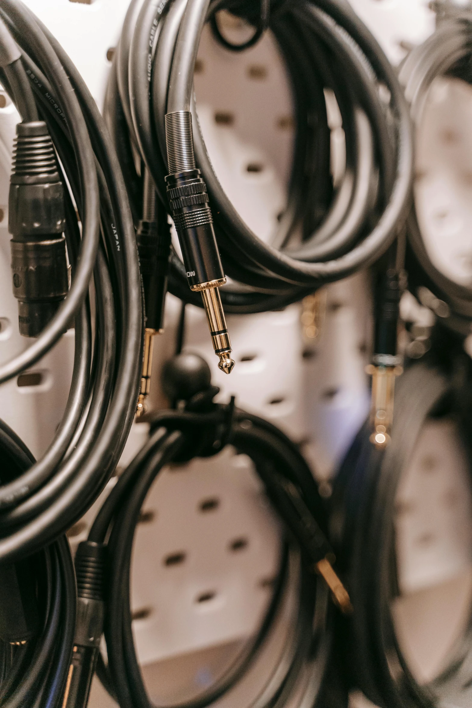 a bunch of cables are hanging on a wall, pexels, studio recording, back room, gold and black metal, hoses:10