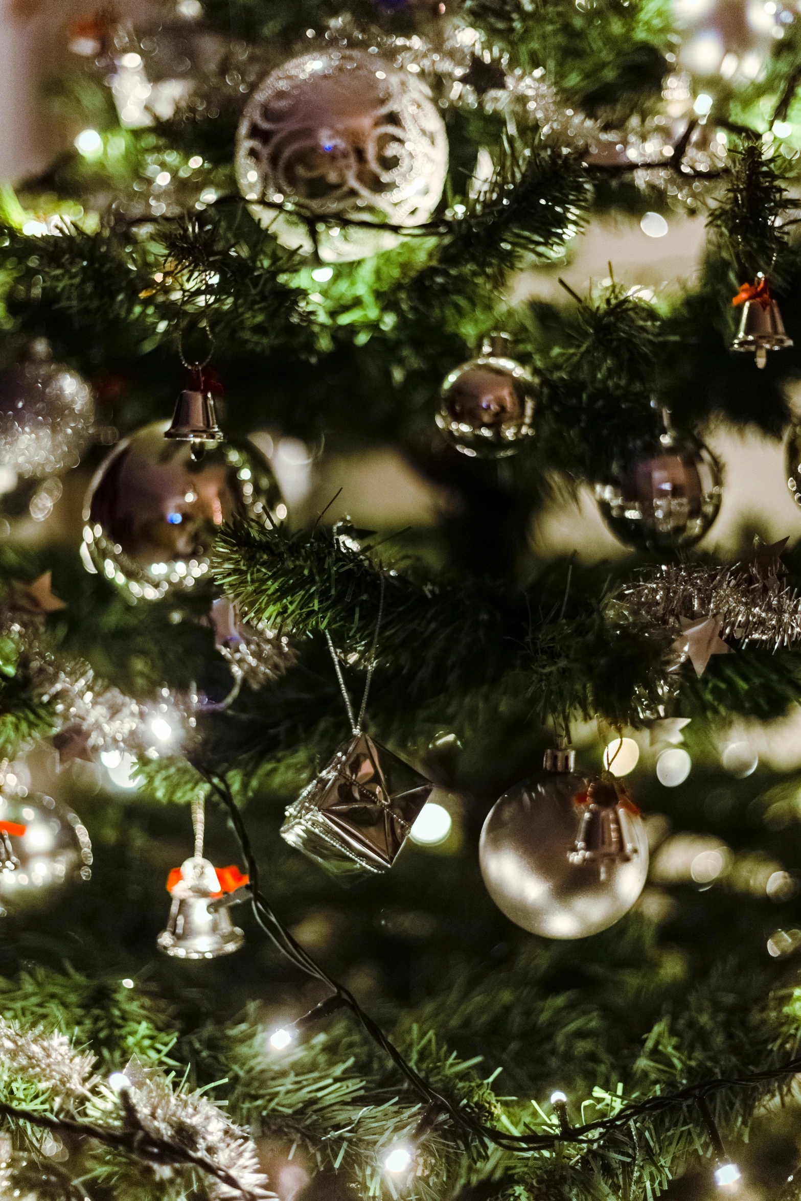 a close up of a christmas tree with ornaments, by Jakob Gauermann, pexels, dappled silver lighting, bells, natural lights, thumbnail