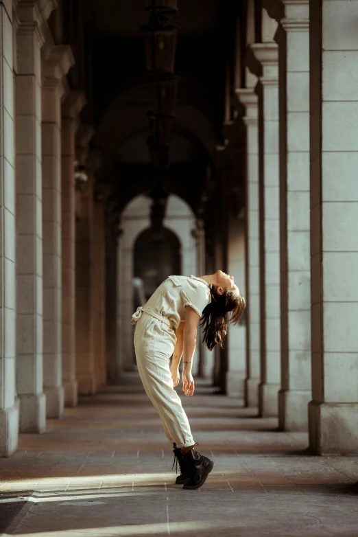 a woman is doing a trick on a skateboard, a picture, inspired by Maciej Kuciara, pexels contest winner, arabesque, wearing white pajamas, there are archways, worried, palace dance