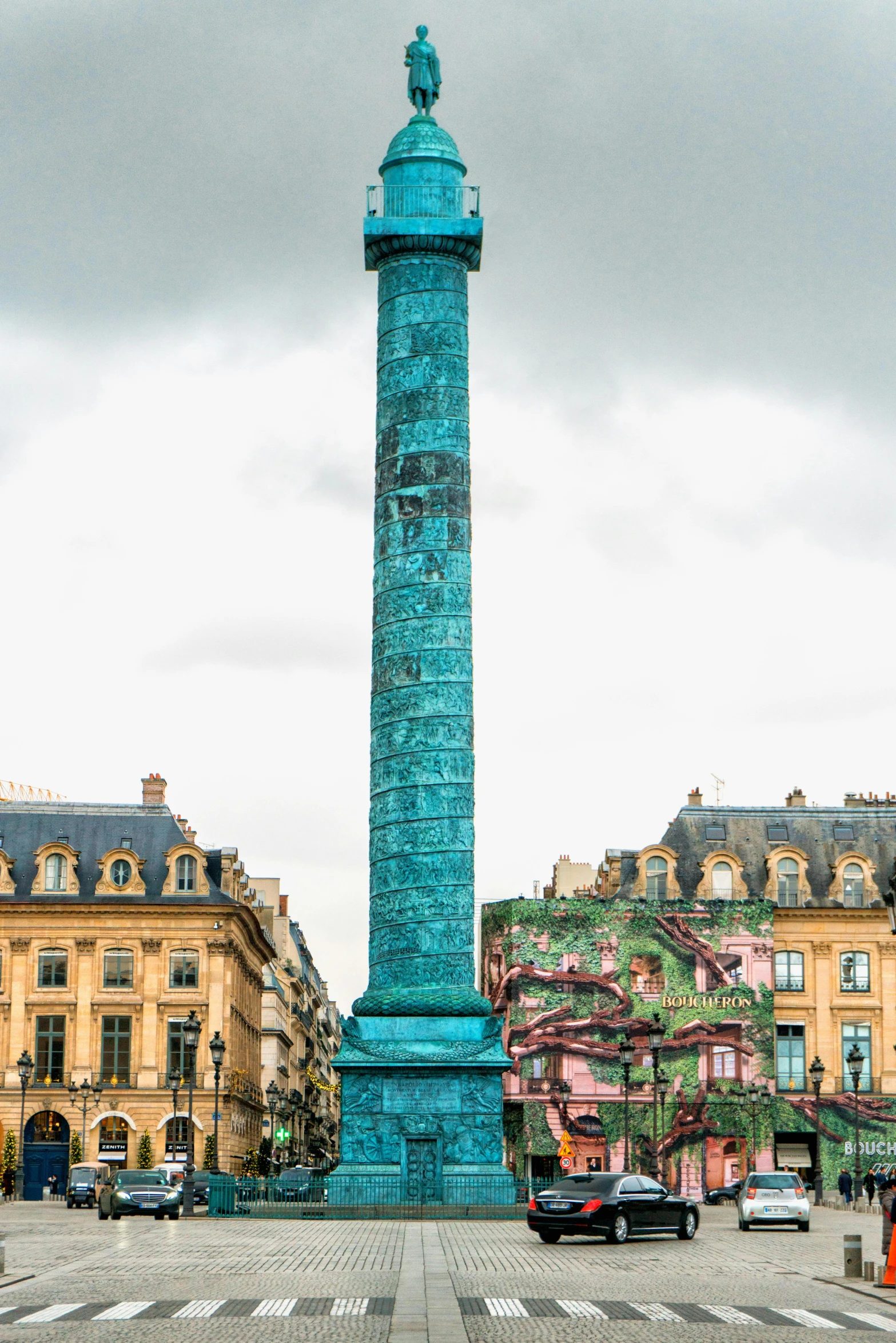 a statue that is sitting in the middle of a street, inspired by François Girardon, neoclassicism, crystal column, verdigris, colorful building, panorama