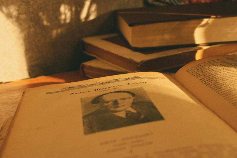 an open book sitting on top of a wooden table, a picture, inspired by László Dombrovszky, private press, background image, yellowed paper, portrait image, film still promotional image