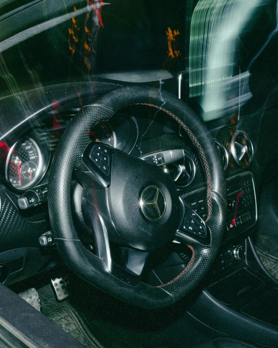 a close up of a steering wheel in a car, by Elsa Bleda, square, mercedes, splash image, maximus jacobs