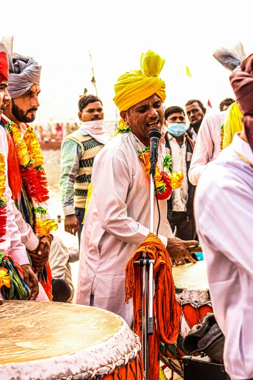 a group of men standing next to each other in front of a drum, pexels contest winner, samikshavad, wearing a turban, the king in yellow, a person at a music festival, square