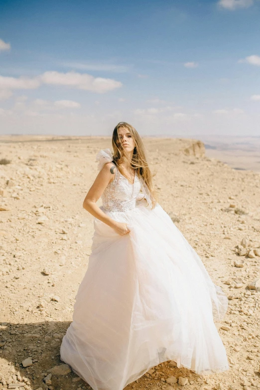 a woman in a wedding dress standing in the desert, israel, curated collections, slide show, windy hair