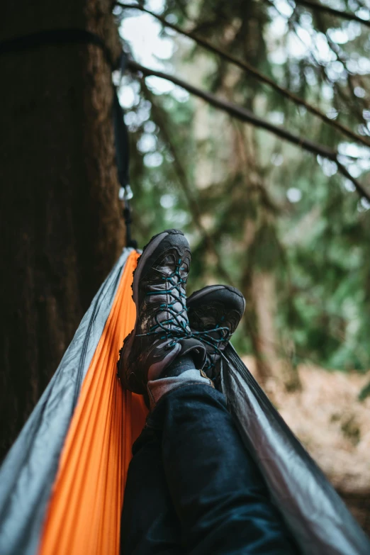 a person laying in a hammock in the woods, pexels contest winner, wearing boots, perched in a tree, adventure gear, slightly minimal