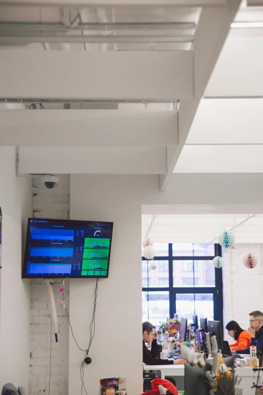 a group of people sitting at tables in a room, ultrastation hq, digital display, uk, zoomed in