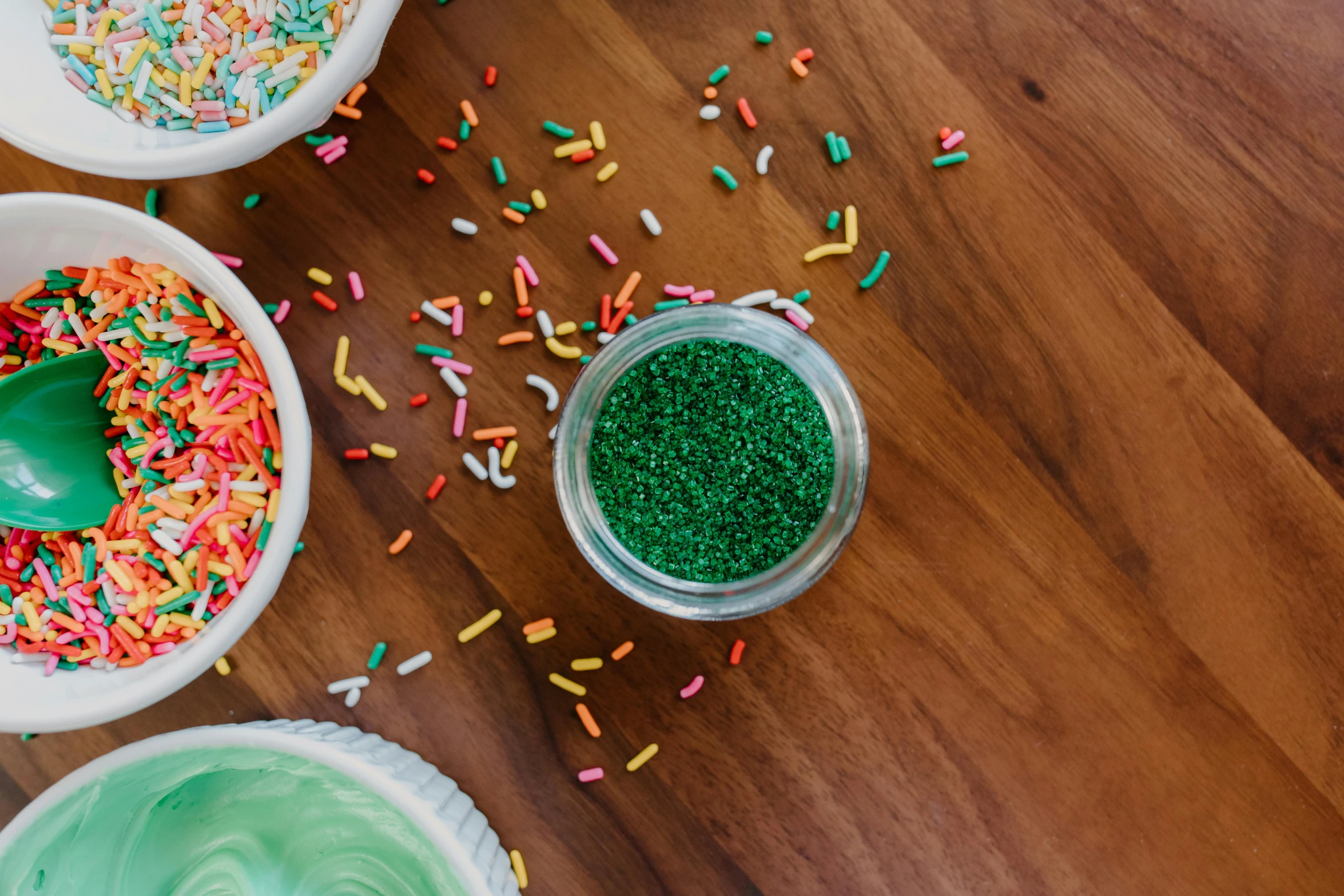 a wooden table topped with bowls of frosting and sprinkles, pexels, green saliva, beads, thumbnail, green