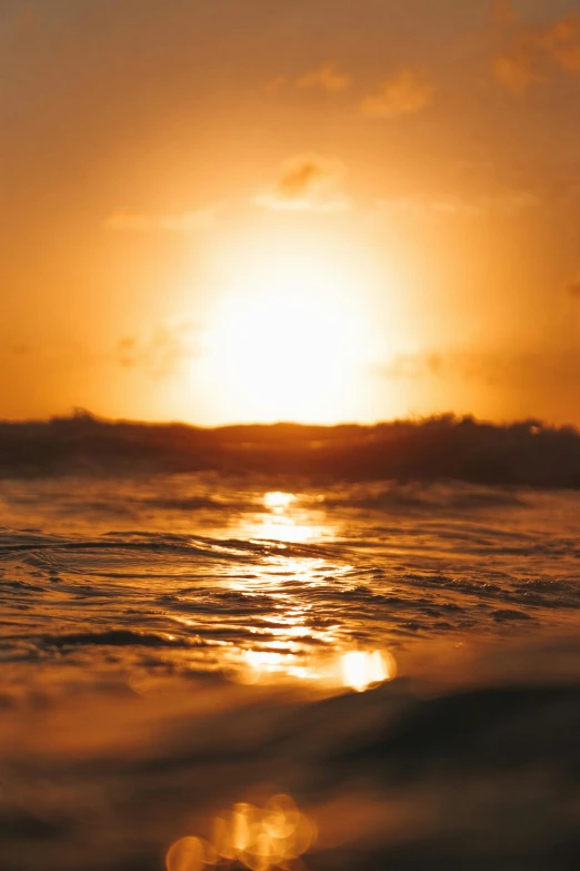 the sun is setting over a body of water, pexels, liquid gold, burning ocean, tan, halogen