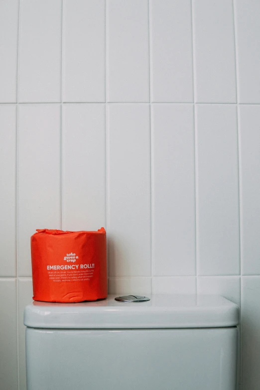 a toilet with a red bag sitting on top of it, by Jessie Algie, unsplash, conceptual art, orange safety vest, milk bath photography, ffffound, news photo