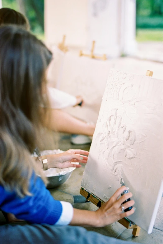 a woman is painting a picture on an easel, a detailed painting, inspired by Peter Paul Rubens, trending on pexels, carved in white marble, embossed, on a canva, high textured