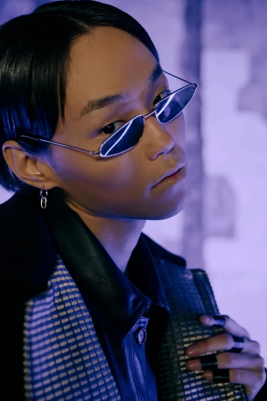 a close up of a person wearing glasses, an album cover, inspired by Zhu Da, trending on pexels, model is wearing techtical vest, bisexual lighting, in a cybercity, androgyny