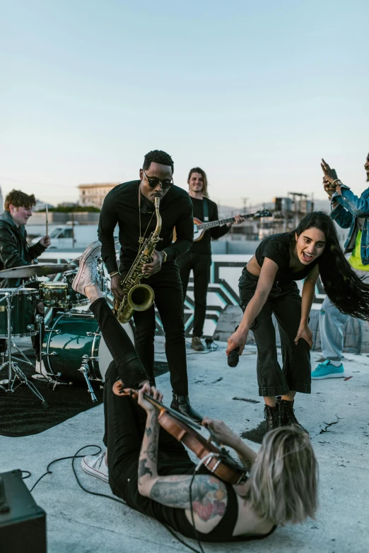 a group of people standing on top of a roof, an album cover, pexels contest winner, black arts movement, saxophones, performing a music video, behind the scenes photo, charli bowater and artgeem