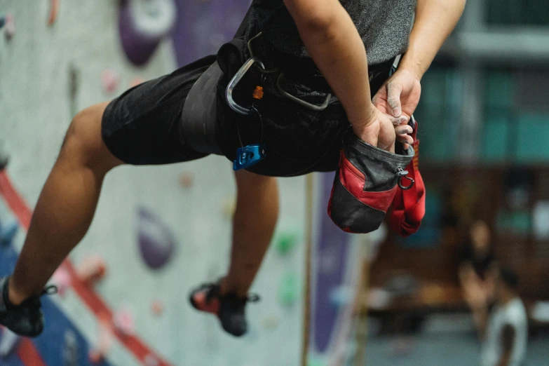 a man climbing up the side of a rock wall, pexels contest winner, in a gym, pouches, manuka, close-up on legs