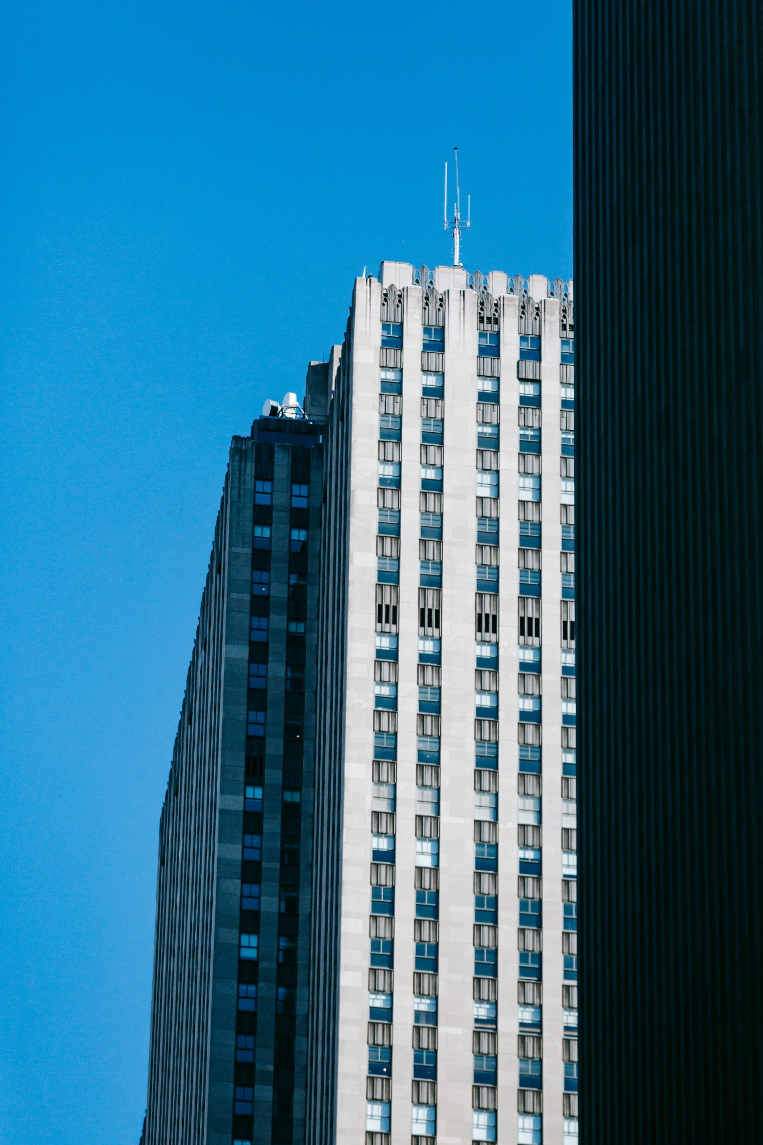 a couple of tall buildings sitting next to each other, by Doug Ohlson, unsplash, clear blue skies, ektachrome color photograph, viewed from afar, telephoto long distance shot