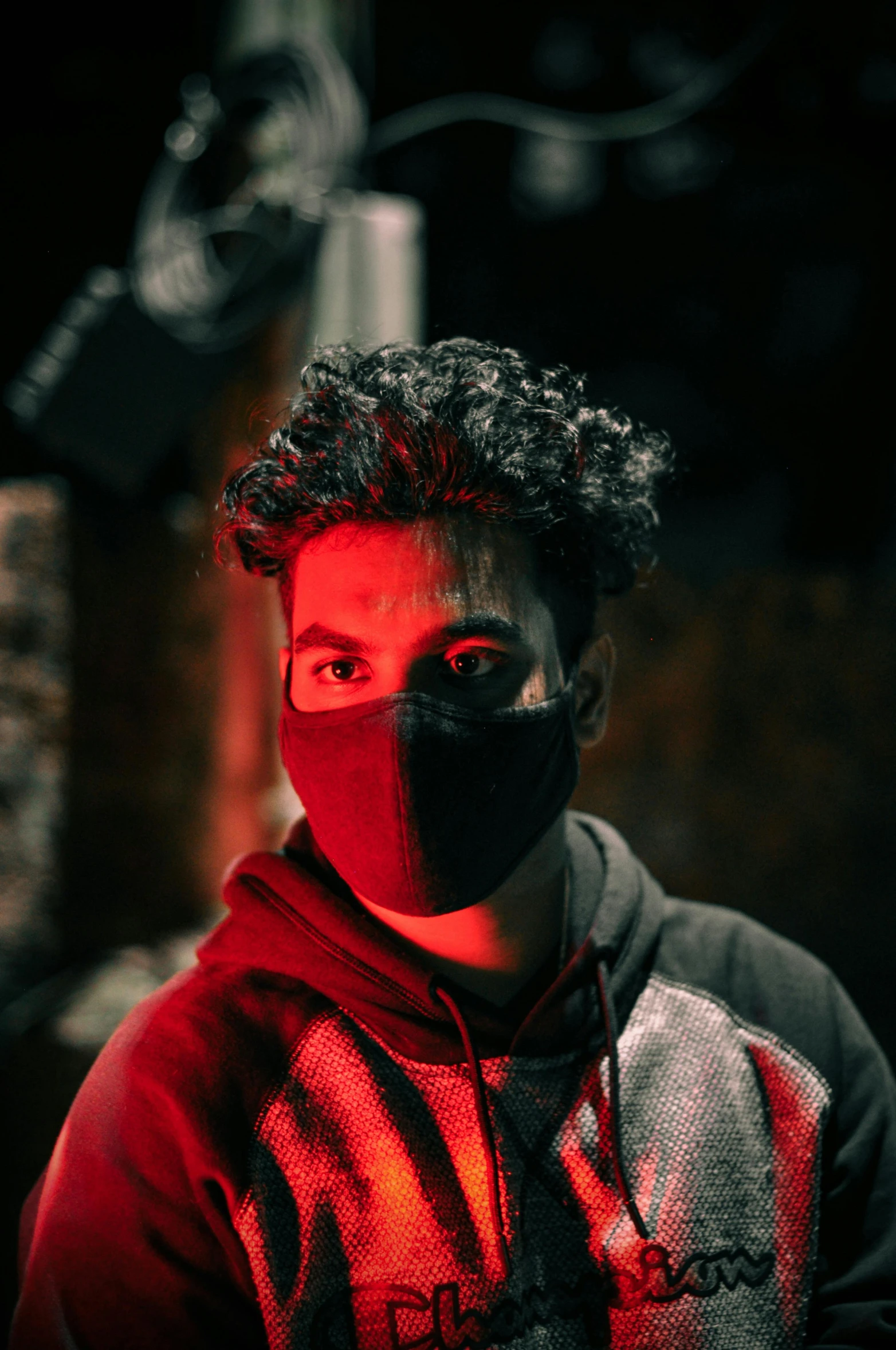 a man wearing a mask in a dark room, riyahd cassiem, gen z, looking at the camera, red and black colors