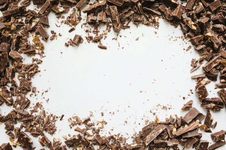 a white plate topped with pieces of chocolate, trending on pexels, visual art, background image, crushed, bark, whitespace border