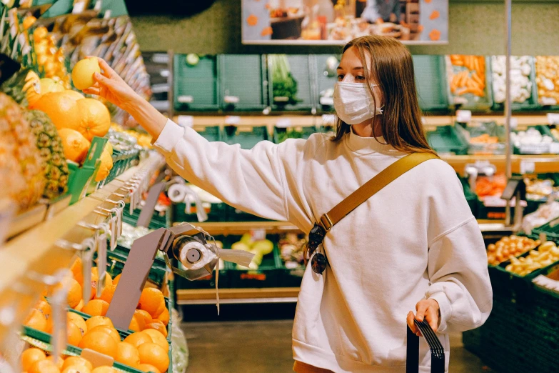 a woman wearing a face mask shopping in a grocery store, a photo, by Julia Pishtar, trending on pexels, 🦩🪐🐞👩🏻🦳, dua lipa, rex orange county, avatar image